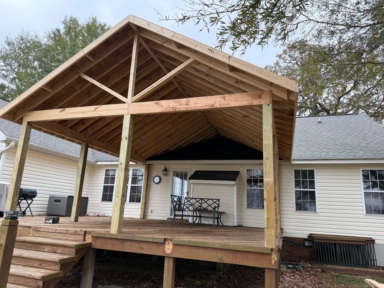 New cedar covered porch with a gable roof tied into a Carolinas home, Charlotte NC