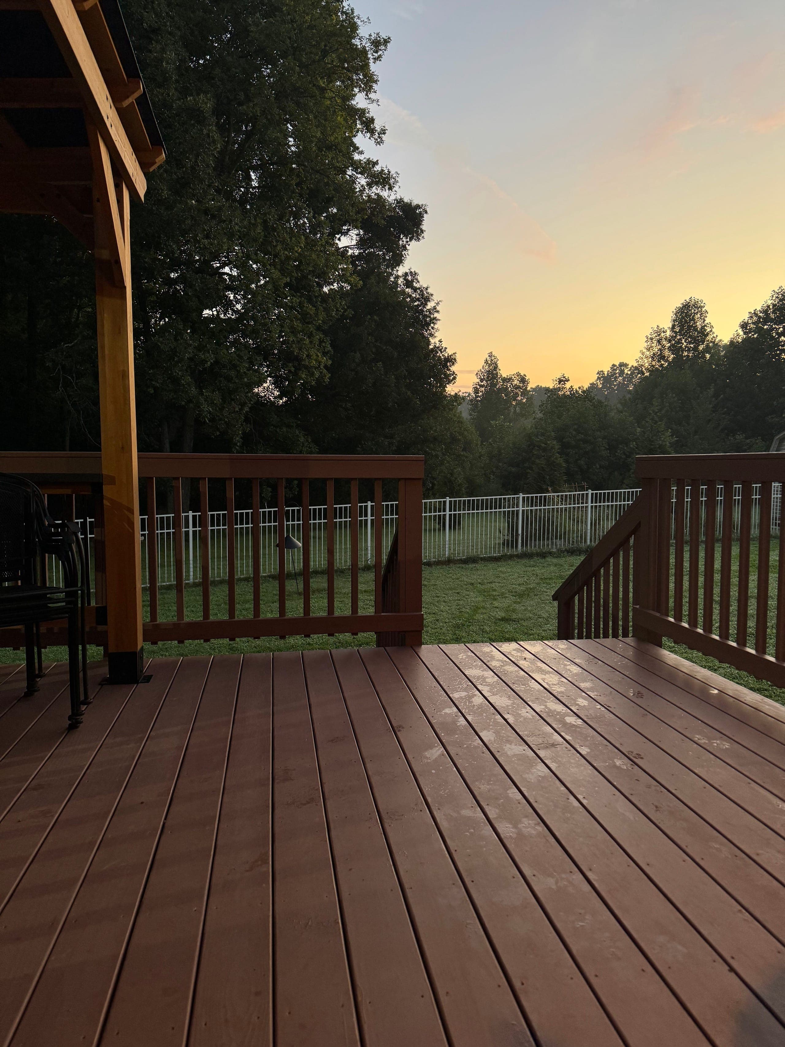 Stained deck under a cedar pavilion looking out to the yard at sunset, Charlotte NC