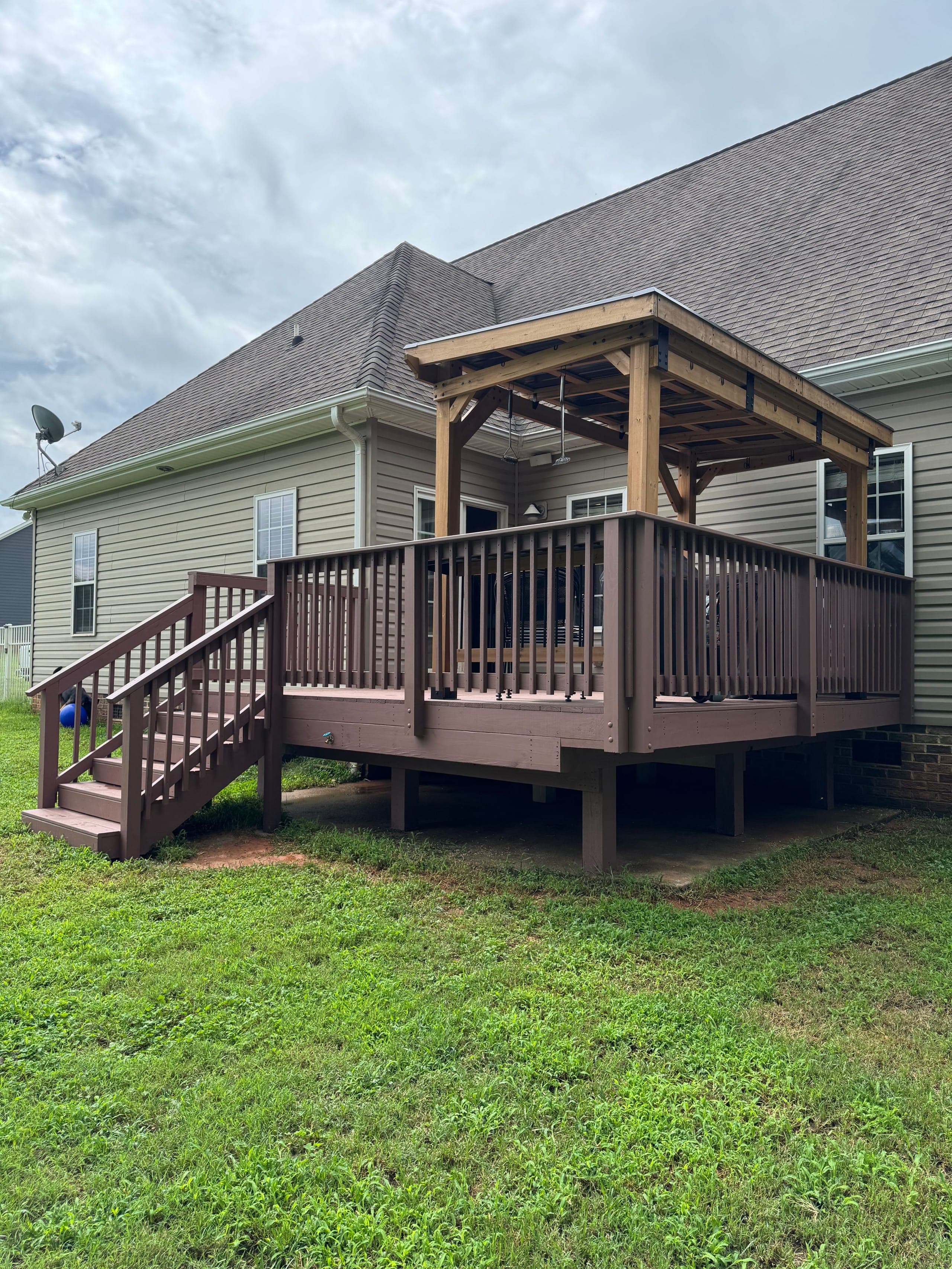 Flat-roof cedar pavilion over a raised backyard deck with painted railings, Mint Hill NC